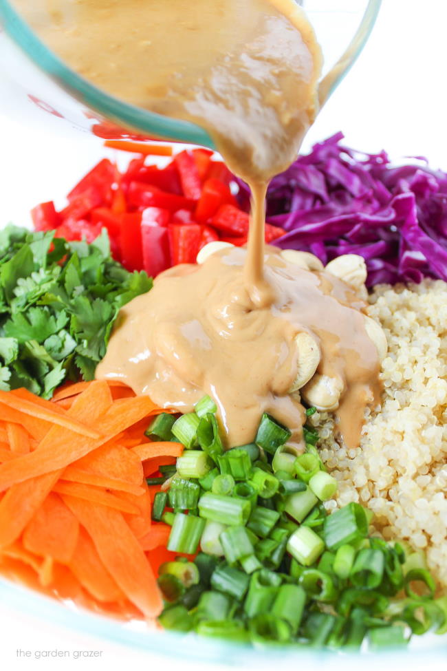 Peanut dressing being poured on fresh ingredients