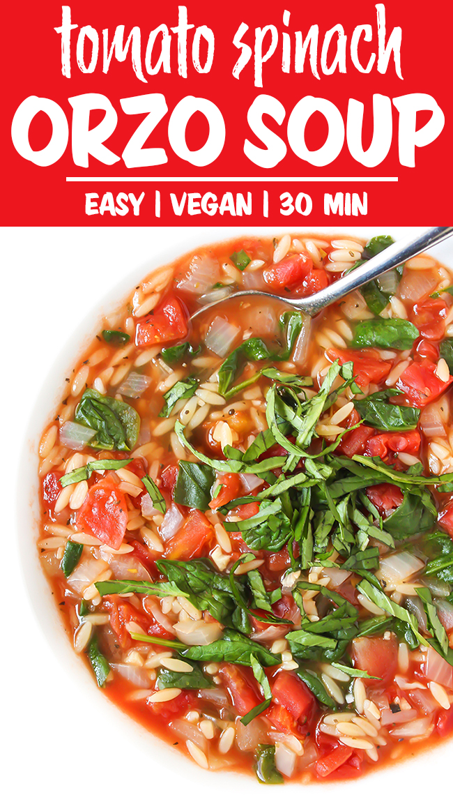 Vegan tomato spinach orzo soup in a bowl with fresh basil ribbons