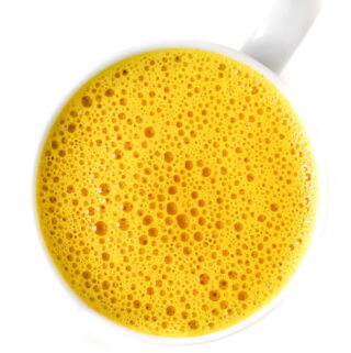 Bright yellow golden turmeric milk latte in a mug