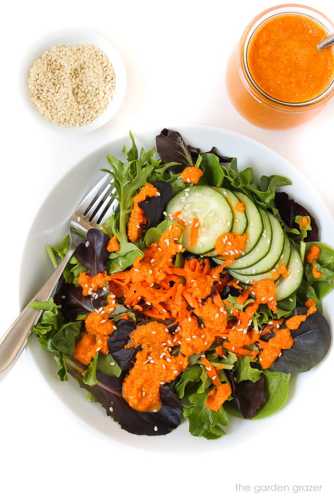Carrot ginger dressing on a green salad in bowl
