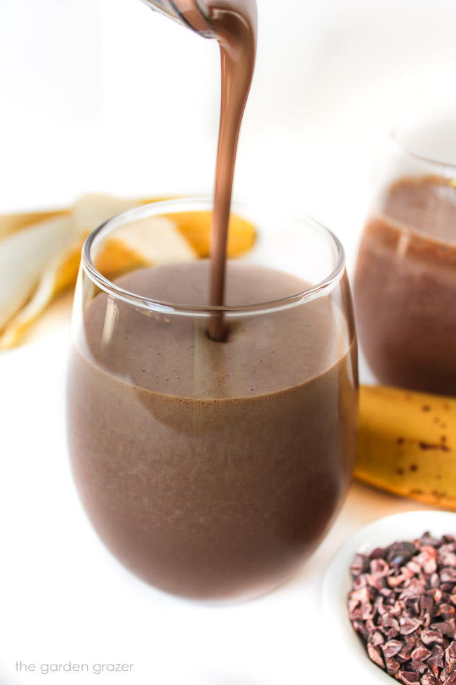 Pouring chunky monkey smoothie into a glass