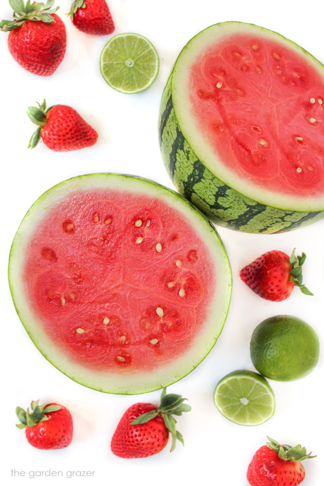 Raw fresh fruit and cut watermelon on a white table