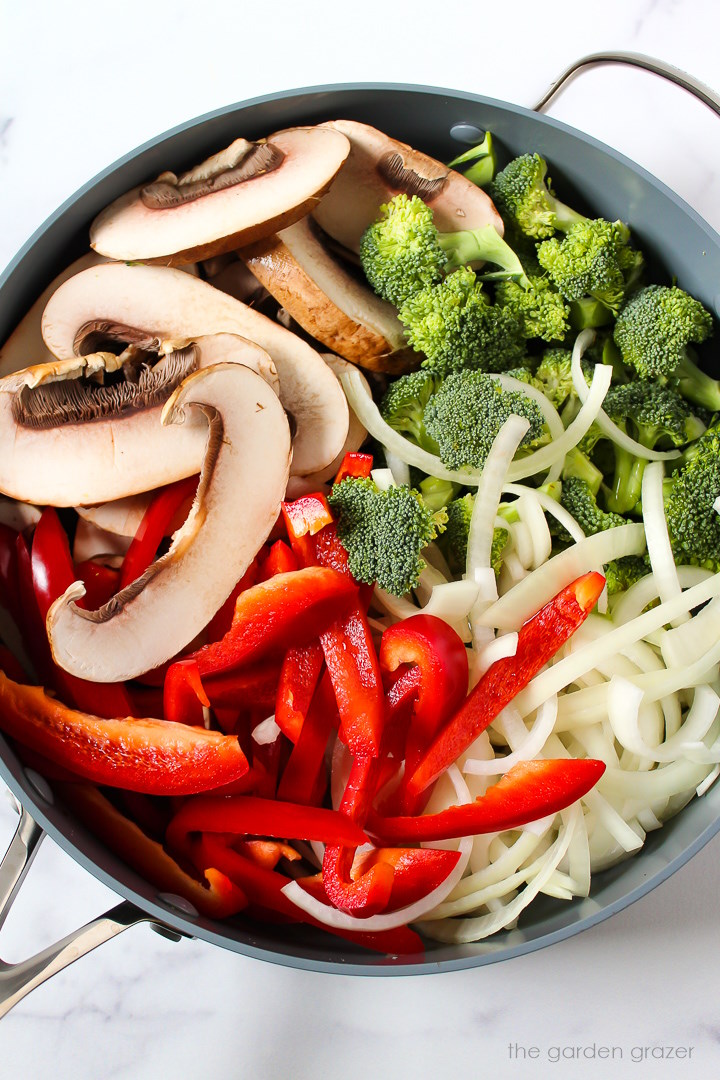Overhead view of preparing stir fry ingredients in a large cooking pan before mixing together