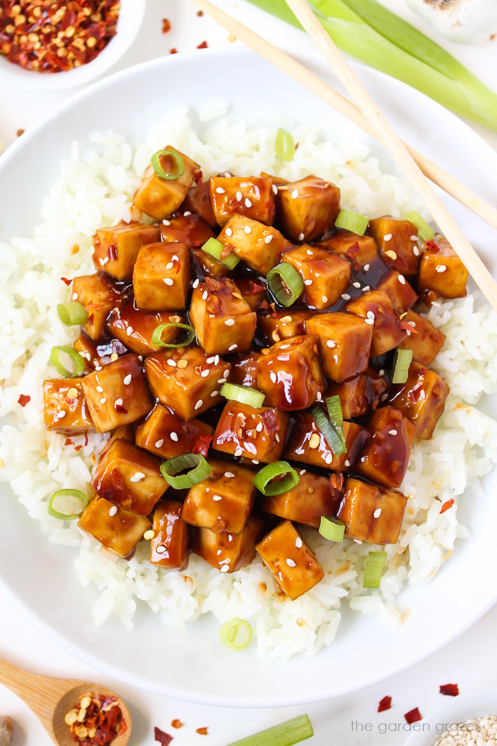 Overhead view of a bowl of baked teriyaki tofu served over rice