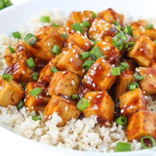 bowl of vegan teriyaki baked tofu topped with sesame seeds