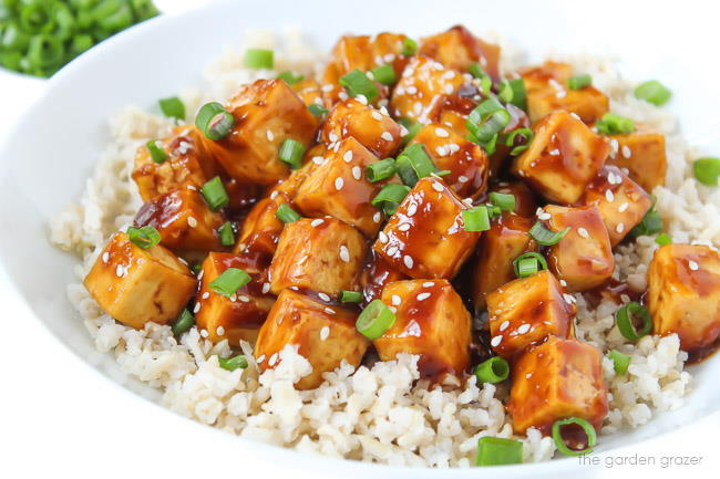 bowl of vegan teriyaki baked tofu topped with sesame seeds