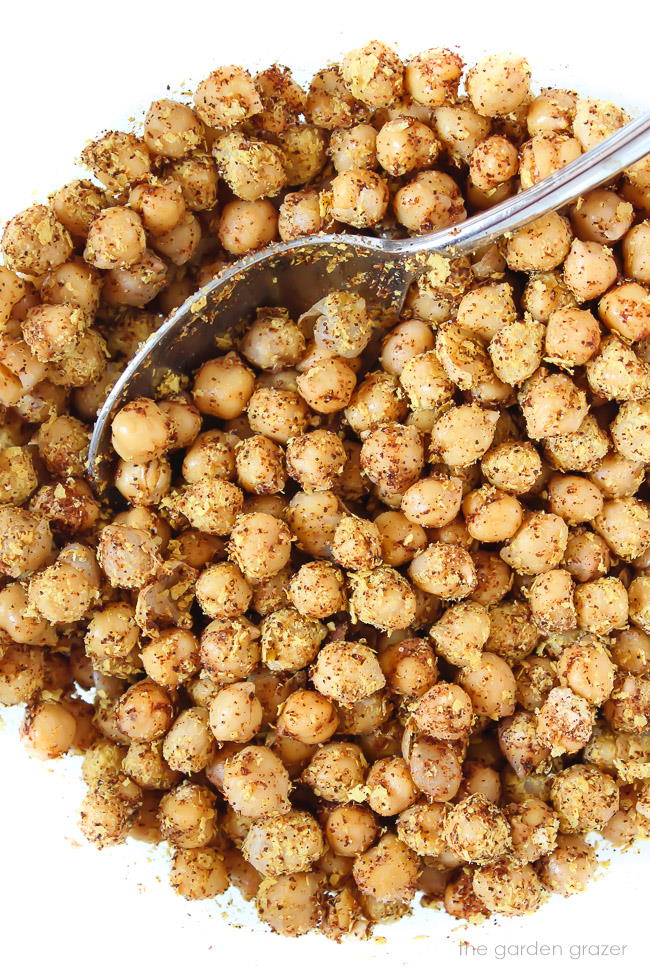 nacho flavored chickpeas in a bowl with spoon before roasting