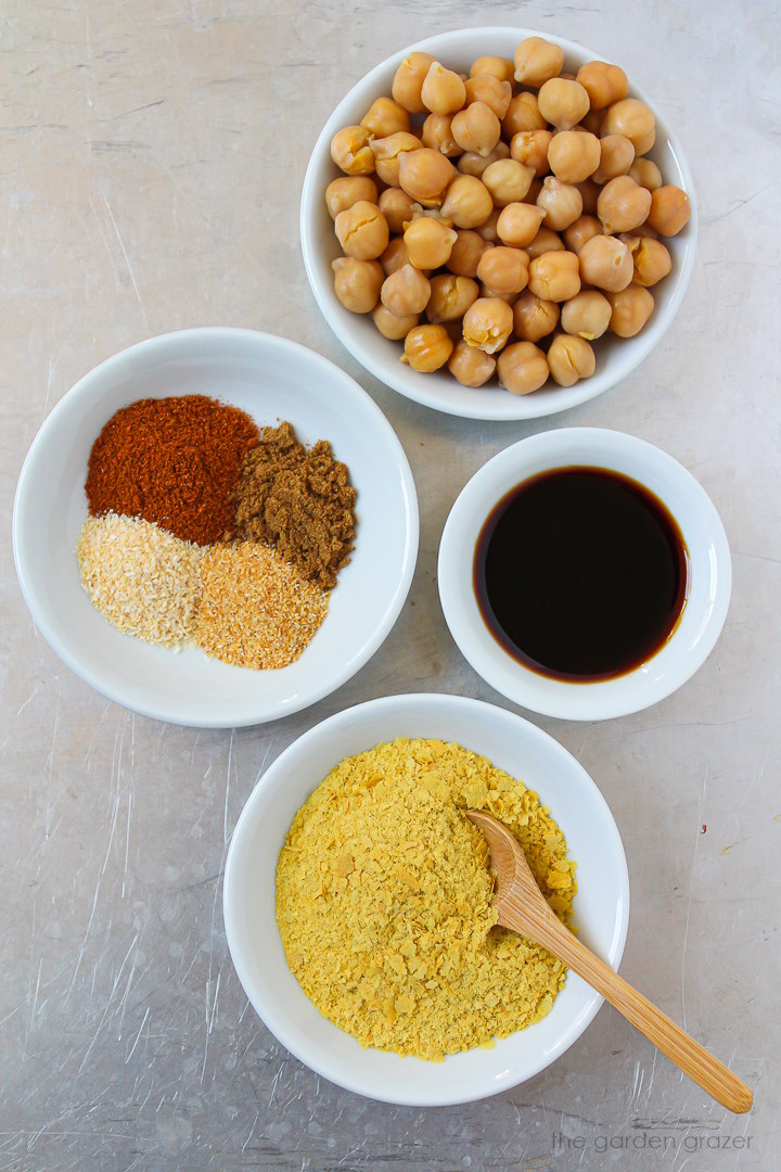 Garbanzo beans, nutritional yeast, tamari, and spice ingredients laid out on a metal tray