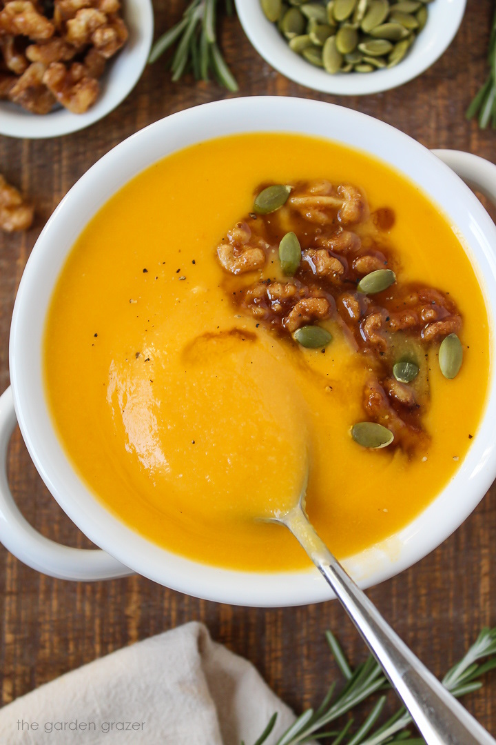 Vegan roasted butternut squash soup in a white serving bowl on a wooden table