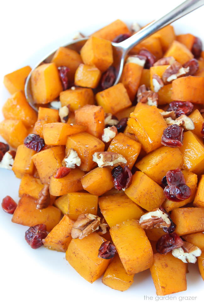 Roasted squash with cranberries and pecans on a white plate