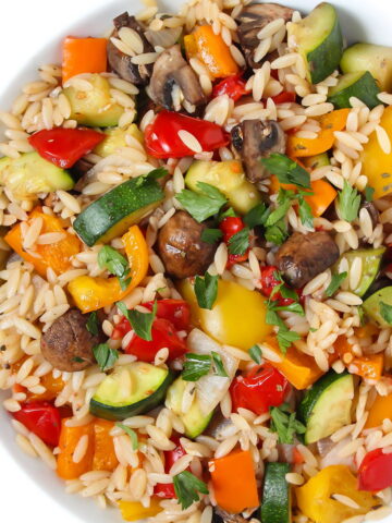 Roasted vegetable orzo with garlic balsamic in a white bowl