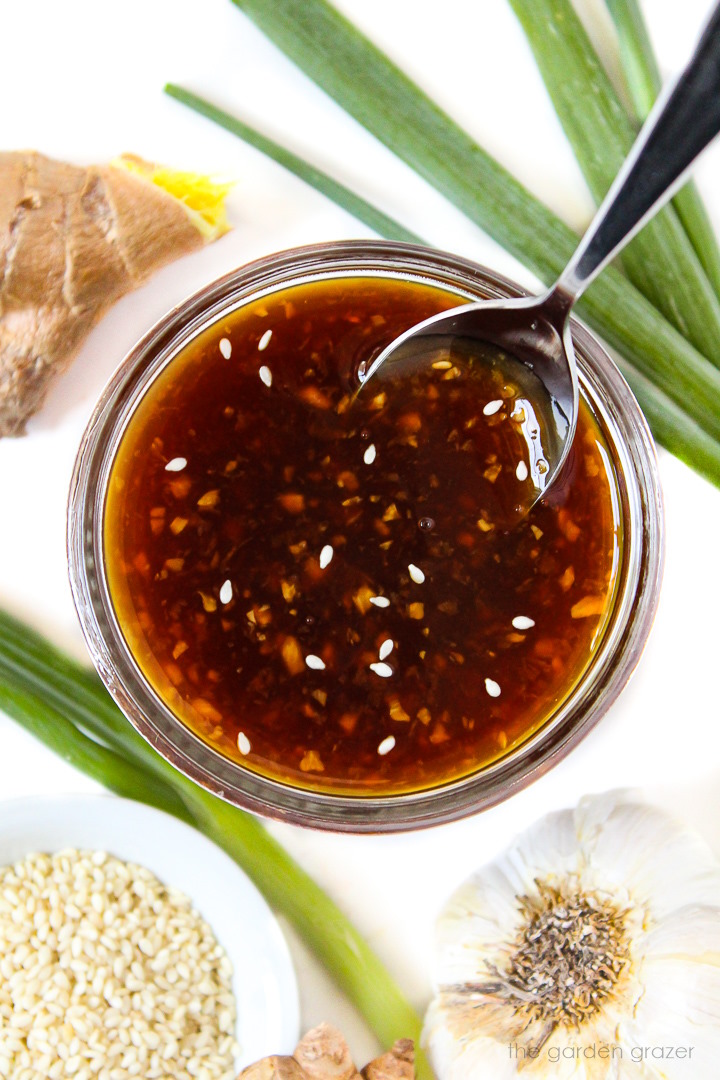 Overhead view of oil-free vegan teriyaki sauce in a glass bowl with serving spoon