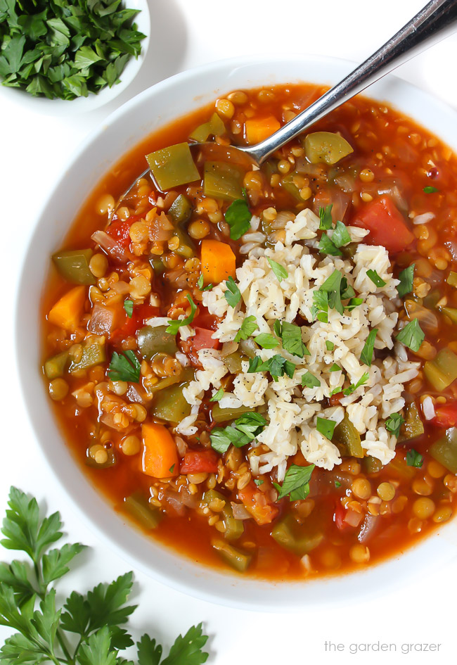 Bowl of stuffed pepper lentil soup topped with brown rice and parsley