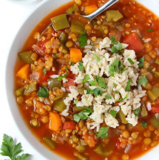 Bowl of stuffed pepper lentil soup topped with brown rice and fresh parsley