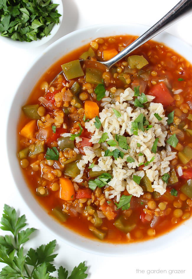 Bowl of stuffed pepper lentil soup topped with brown rice and fresh parsley