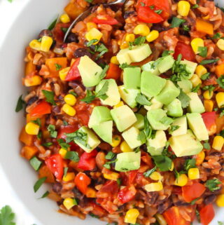 Vegan beans and rice in a bowl topped with avocado