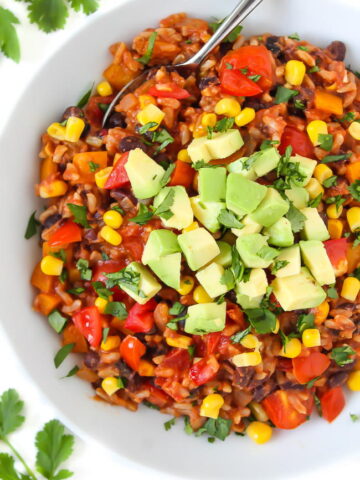 Vegan beans and rice in a bowl topped with avocado