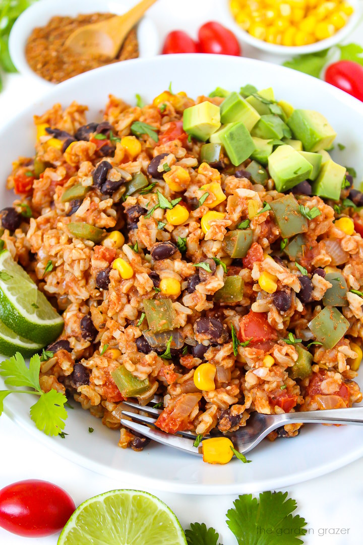 Close up view of fiesta rice and black beans in a white bowl with serving fork