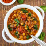 Smoky lentil tomato soup in a white serving bowl on a wooden table