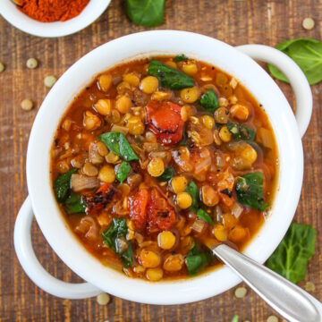 Smoky lentil tomato soup in a white serving bowl on a wooden table