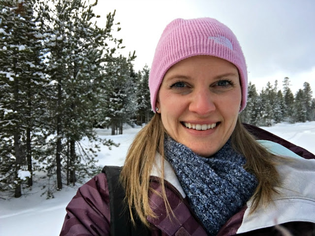 Kaitlin outdoors in the Montana winter with snowy pine trees