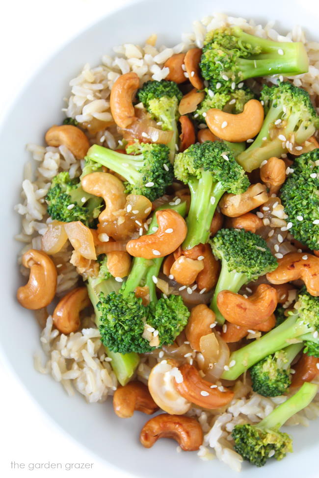 Vegan stir-fry in a white bowl on top of brown rice