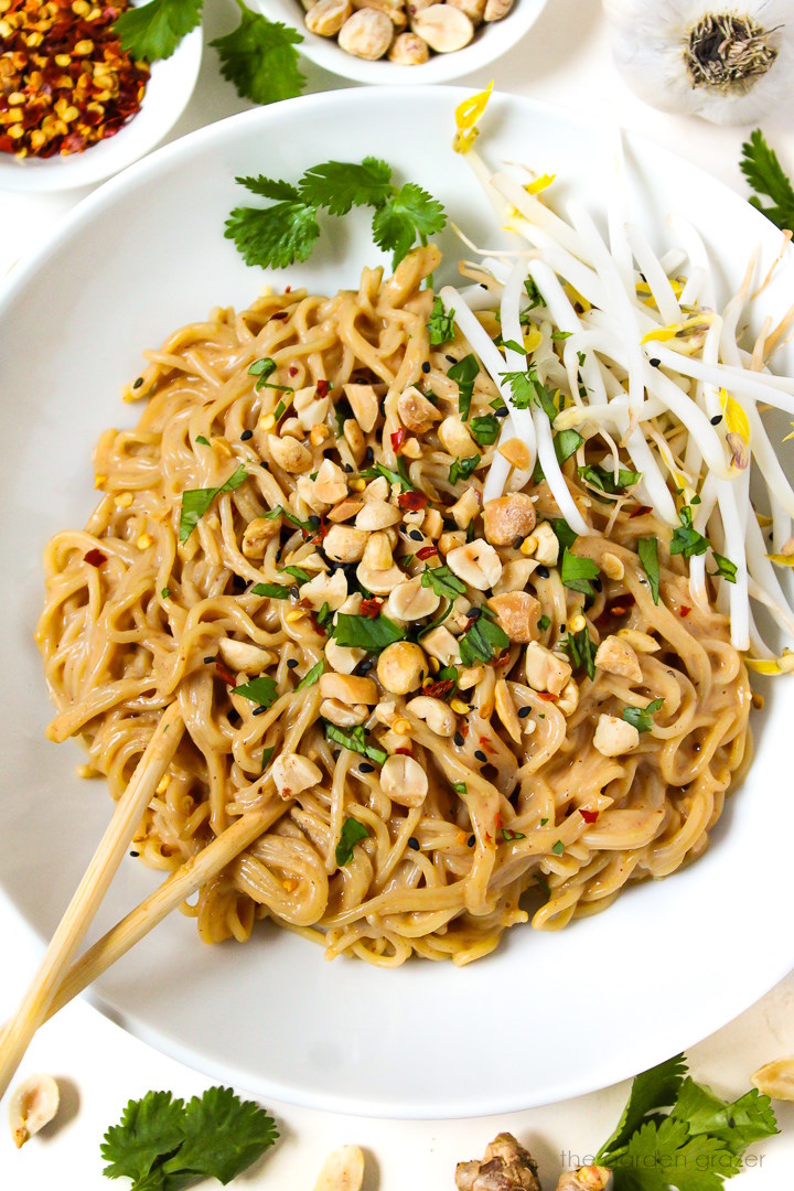 Overhead view of easy vegan peanut noodles served in a white bowl with mung bean sprouts