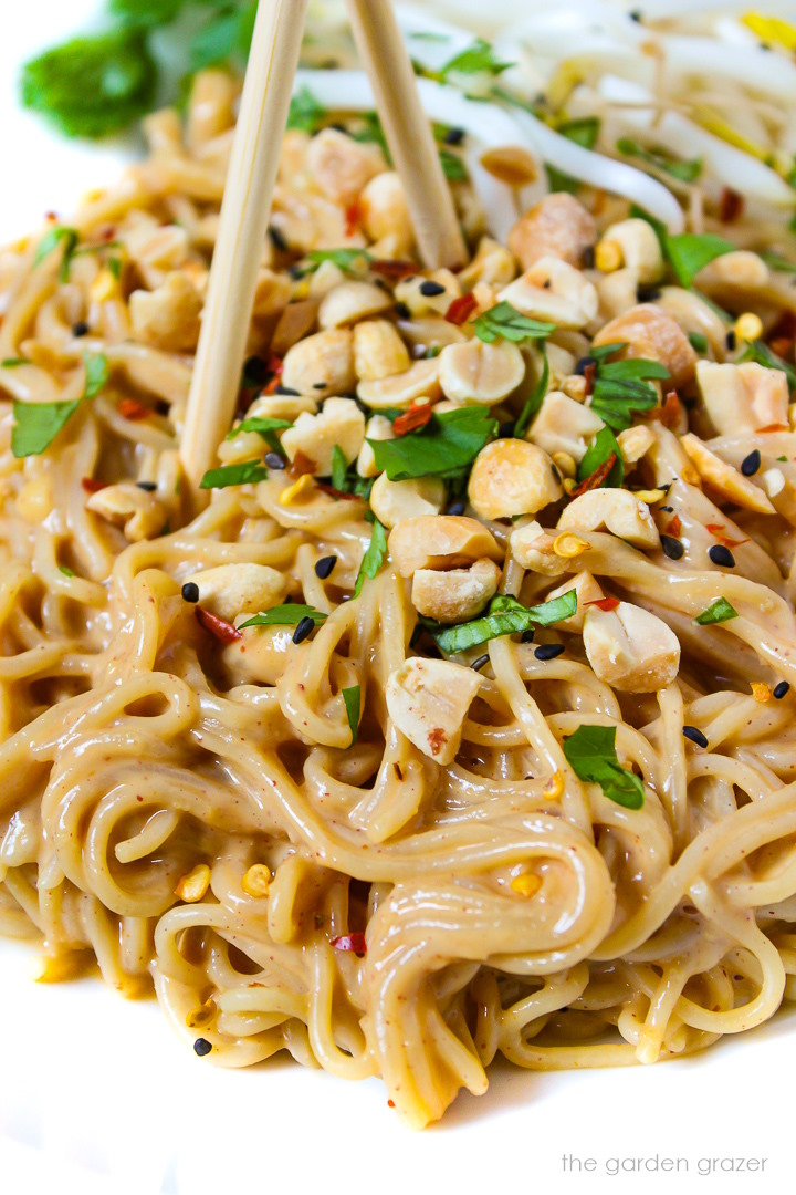 Close up view of easy vegan peanut noodles on a white plate with fresh cilantro