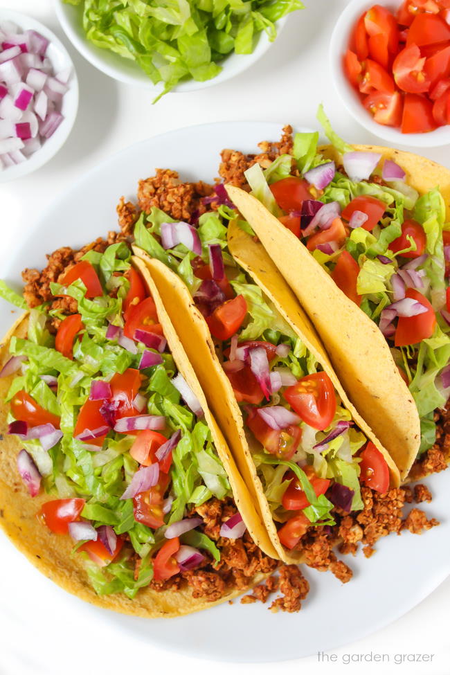 Plate of chickpea walnut tacos with lettuce, tomato, and onion