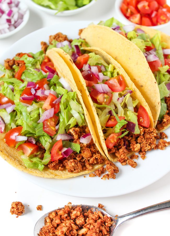 Plate of three vegan tacos with chickpea-walnut taco filling