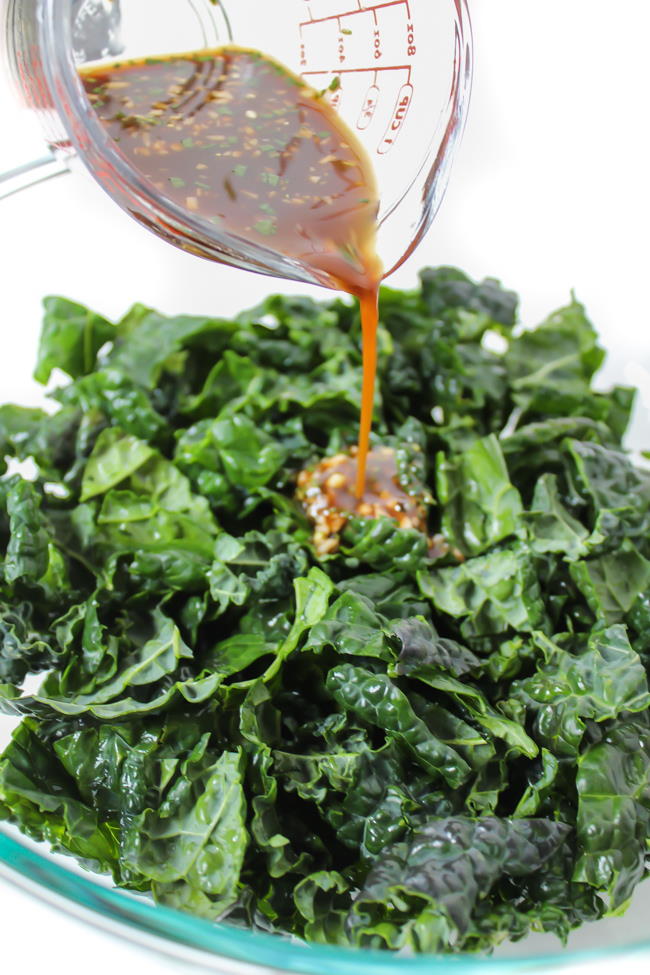 rosemary maple balsamic dressing being poured over chopped kale
