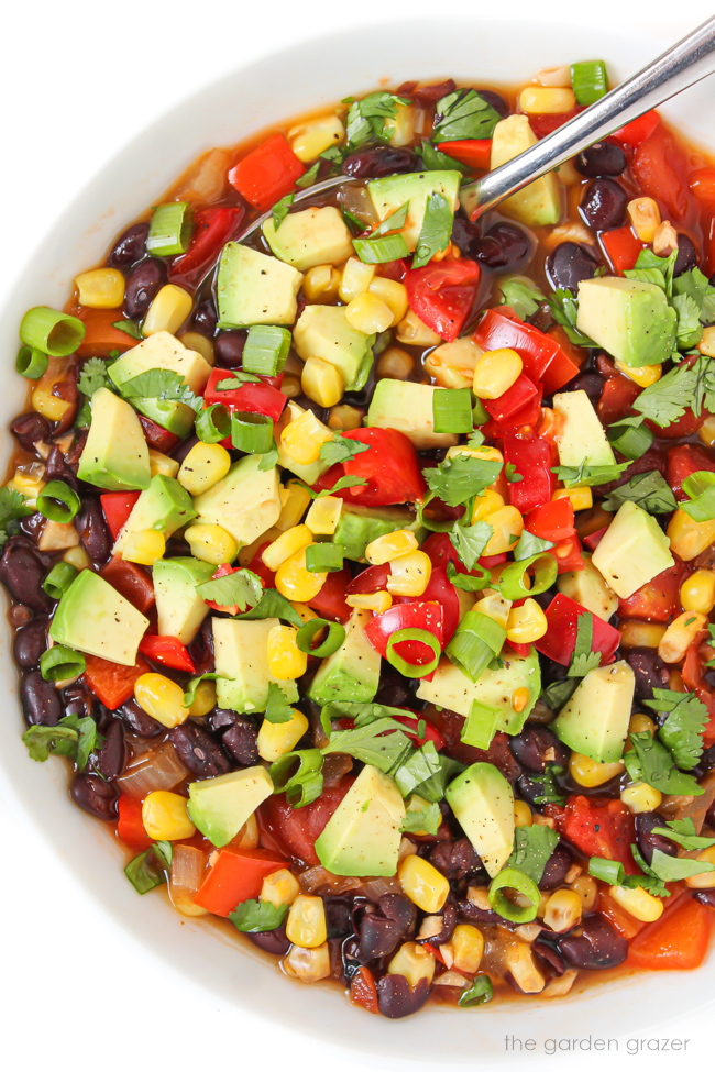 Vegan southwest soup with black beans in a white bowl with spoon