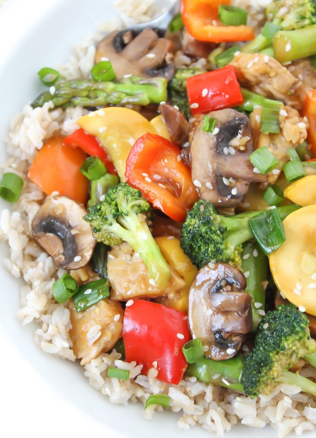 Vegetable tempeh teriyaki stir fry in a bowl with brown rice
