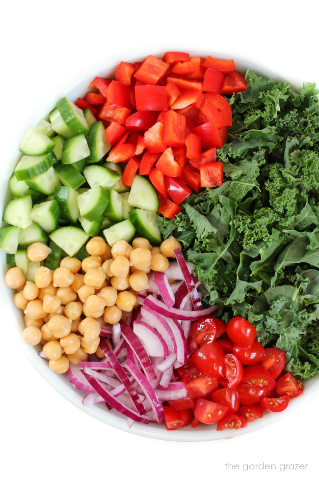 Ingredients for Kale Greek Salad in a large bowl
