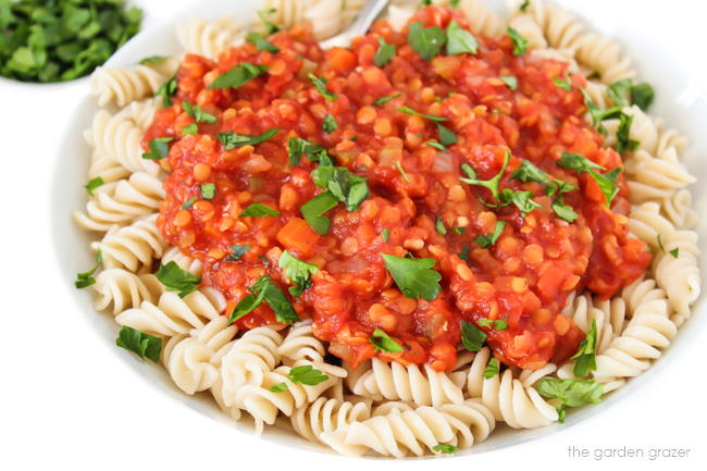 Bolognese over pasta in a bowl with fresh parsley