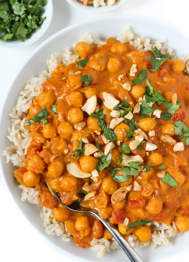 Bowl of vegan butter chickpeas and rice topped with cashews