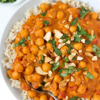 Bowl of vegan butter chickpeas and rice topped with cashews