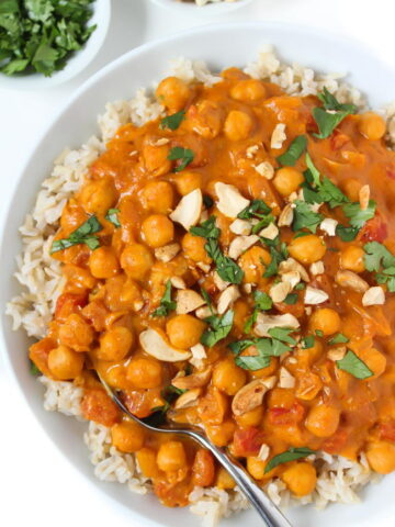 Bowl of vegan butter chickpeas and rice topped with cashews