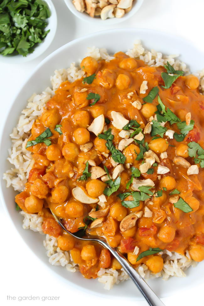 Bowl of vegan butter chickpeas and rice topped with cashews