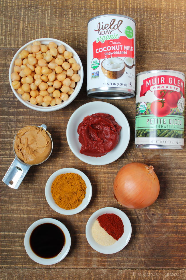 Beans, spices, onion, and canned ingredients laid out on a wooden table