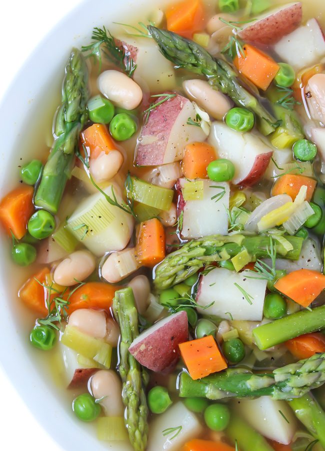 Bowl of vegan spring minestrone soup with fresh dill