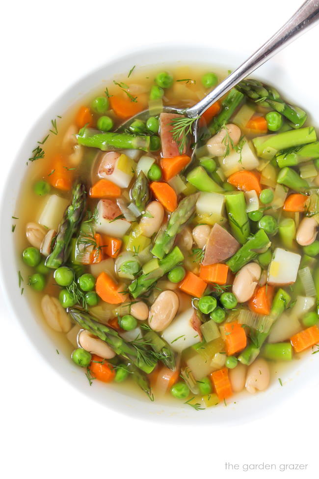 Bowl of spring vegetable minestrone soup with spoon