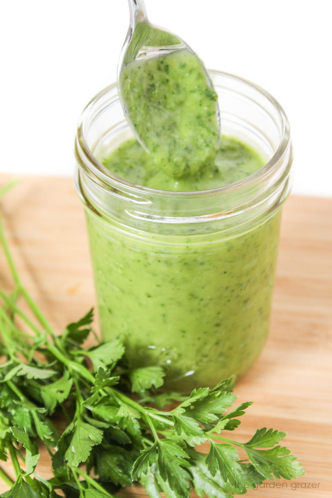 Jar of creamy herb dressing with avocado and parsley