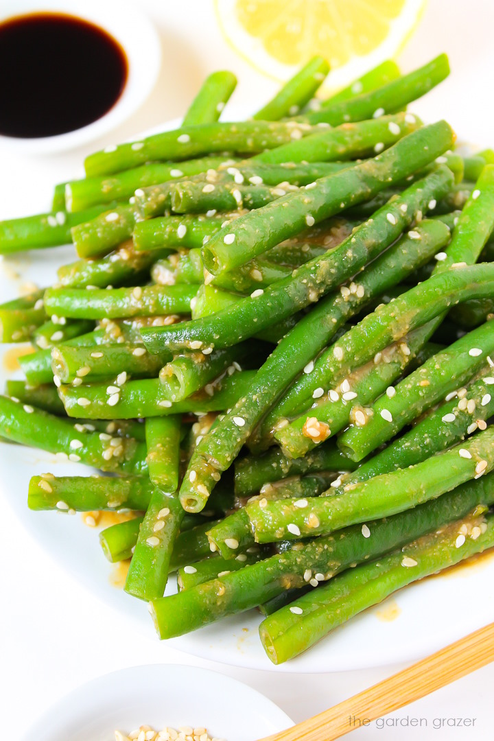 Close up view of miso glazed green beans on a white plate