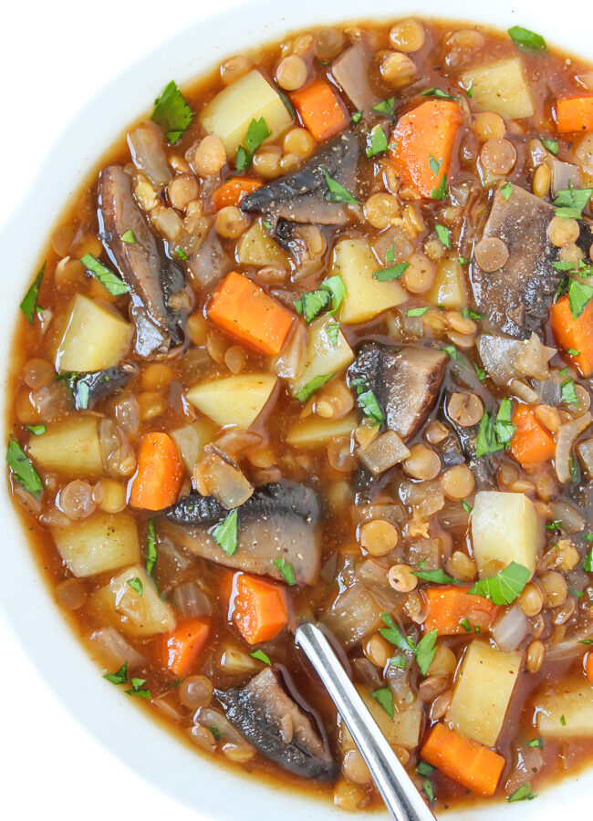 Vegan mushroom potato lentil stew in a bowl with spoon