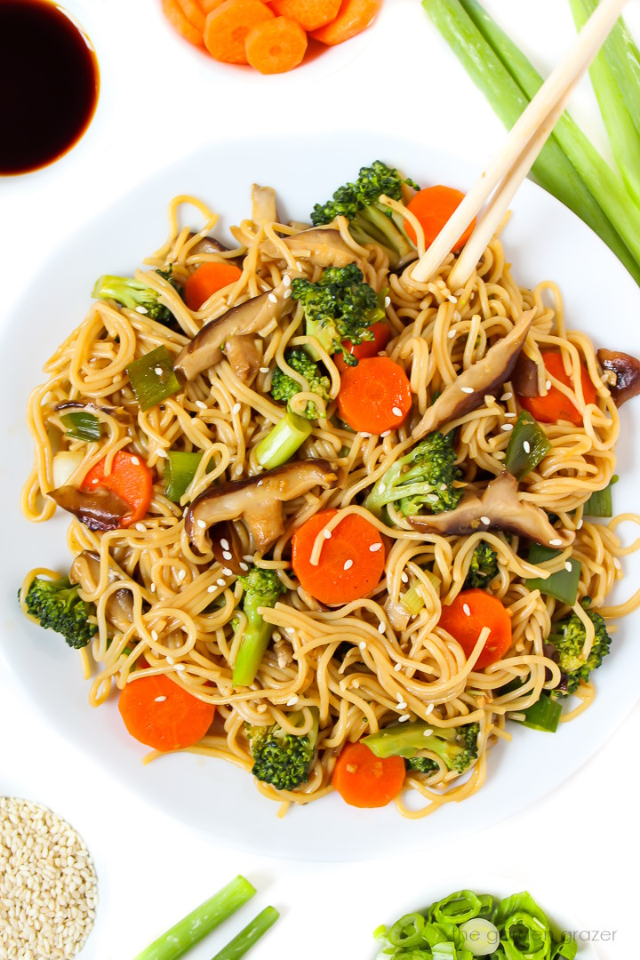 Teriyaki noodles with vegetables on a white plate with chopsticks