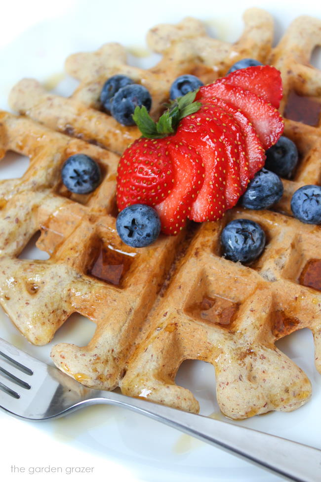 Vegan waffle on a plate with maple syrup and berries