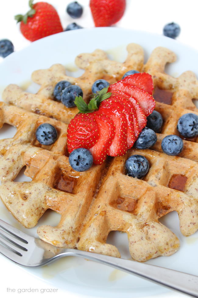 Gluten-free vegan waffle on a plate with strawberries and blueberries