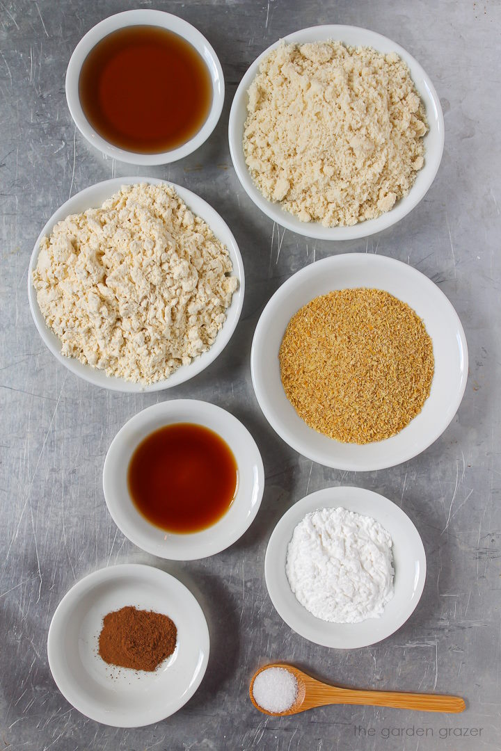 Flour, maple syrup, ground flax, vanilla extract, baking powder, and spice ingredients laid out on a metal tray