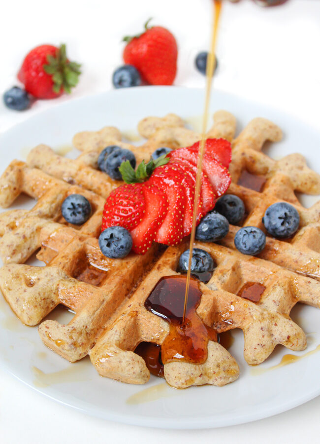 Plate of vegan gluten-free waffles with maple syrup